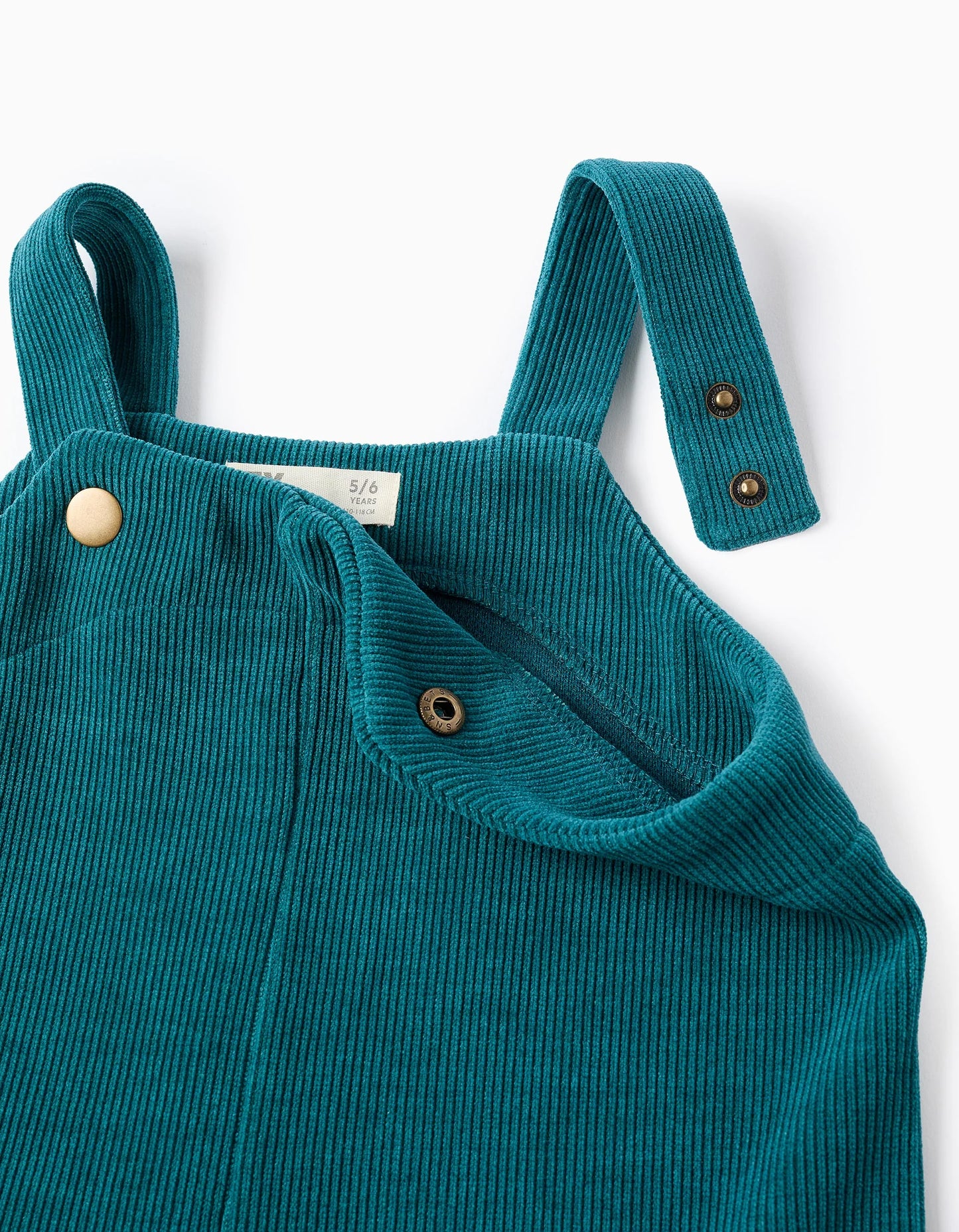 Peto de punto trenzado con bolsillos para niña azul